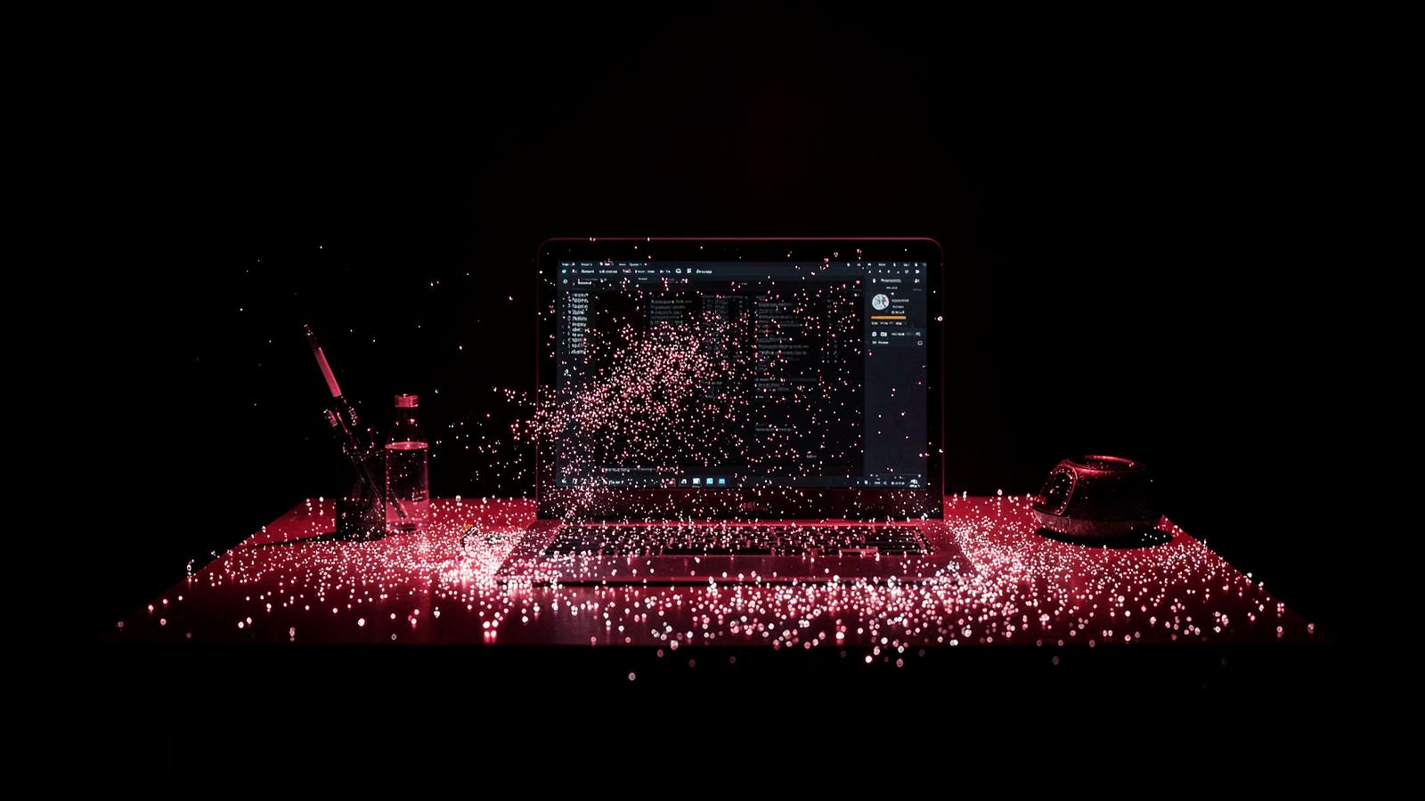 Dark creative studio desk with generative AI particles and red accent light